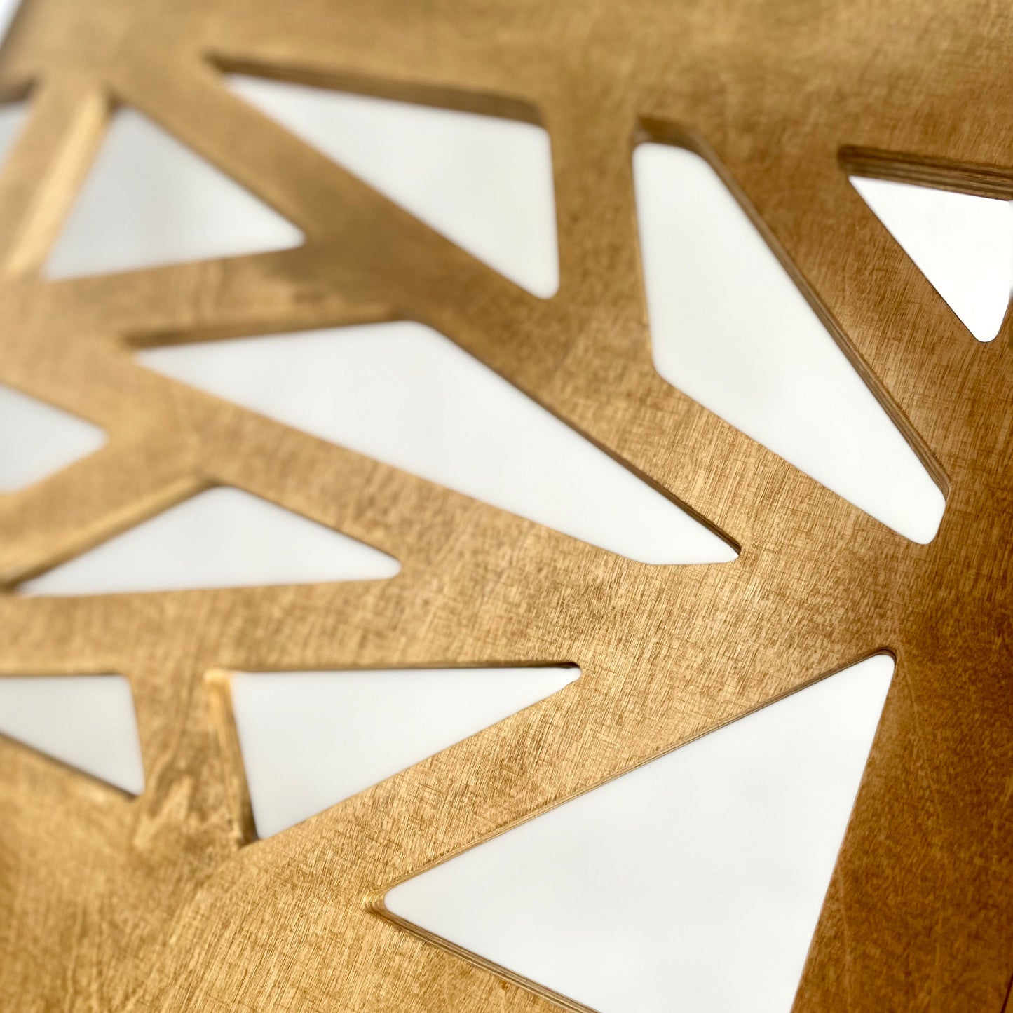 Close-up of a gold geometric decorative item on a white background