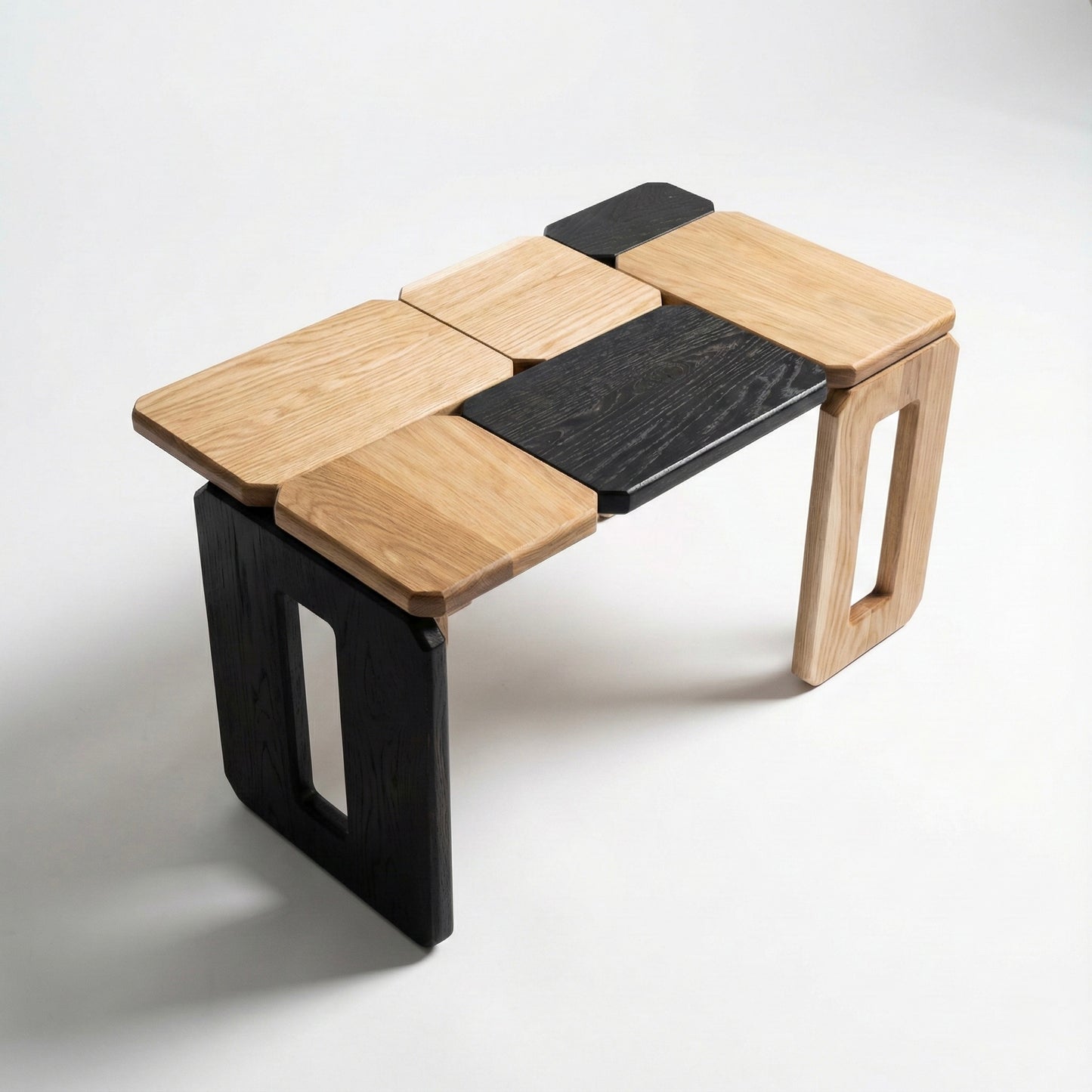 Modular wooden coffee table with black and natural wood panels on a white background