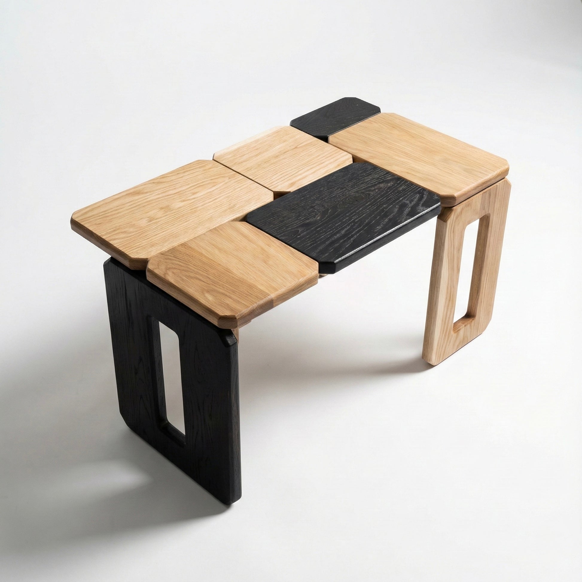 Modular wooden coffee table with black and natural wood panels on a white background