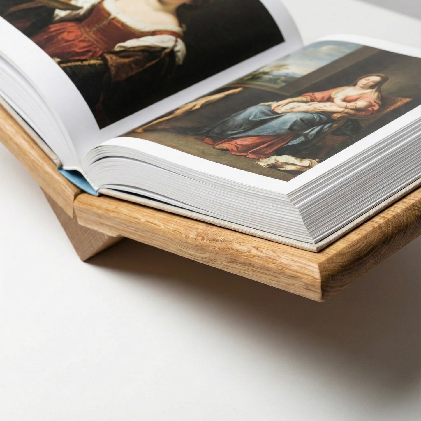 Open book with artistic illustrations on a wooden stand