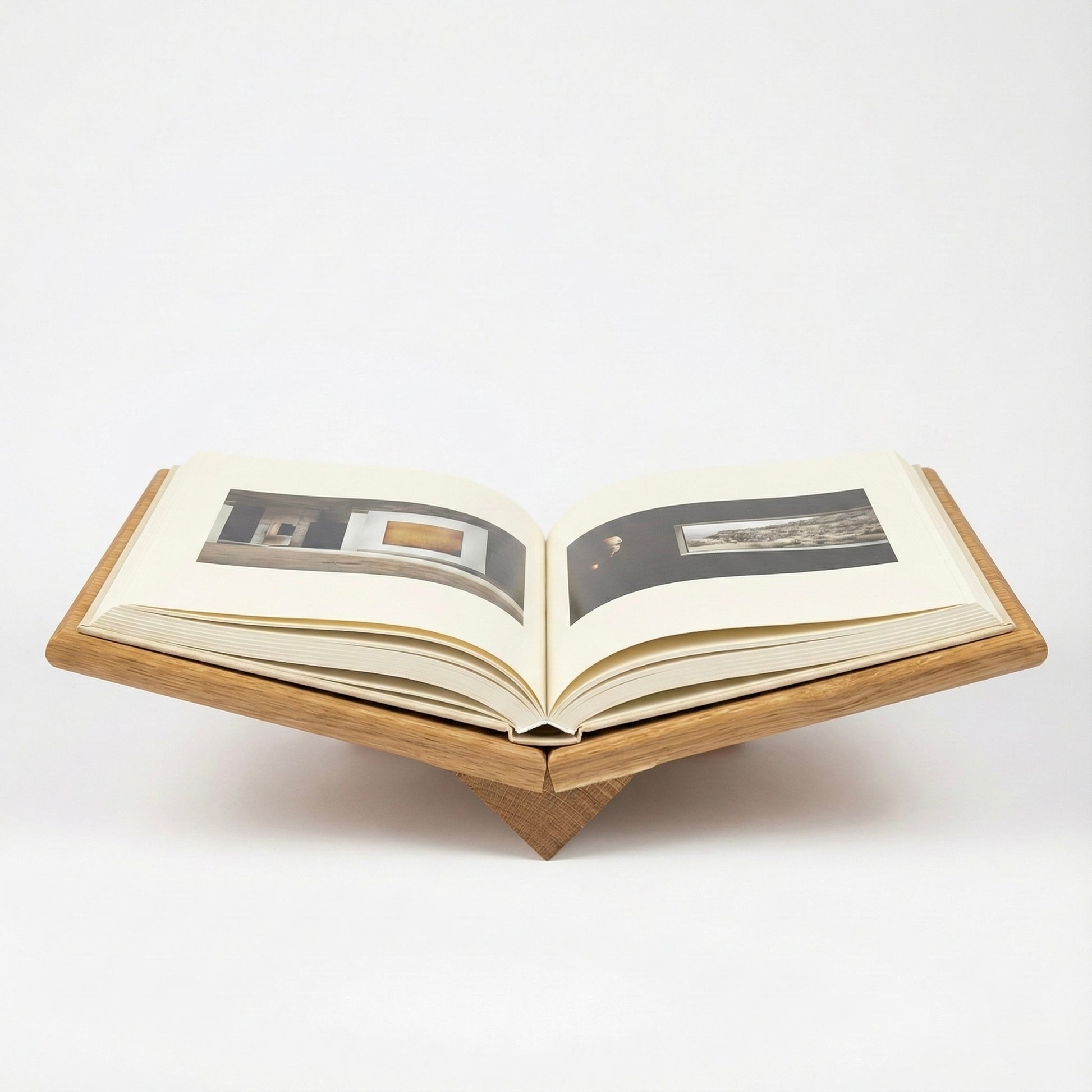 Open book on a wooden stand with images inside, on a white background