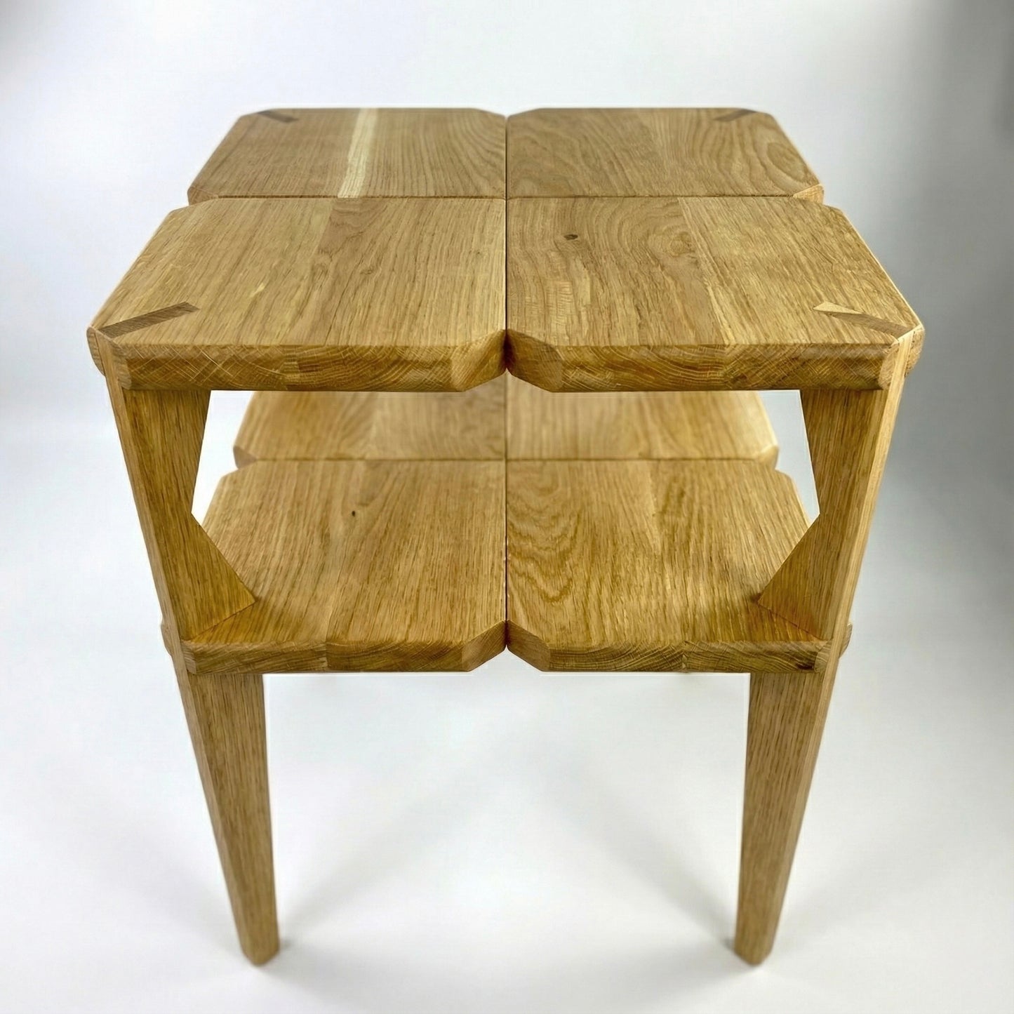 Wooden bedside table with two square shelves on a white background