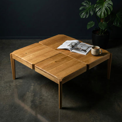 Wooden coffee table with a magazine and a cup on a dark floor.