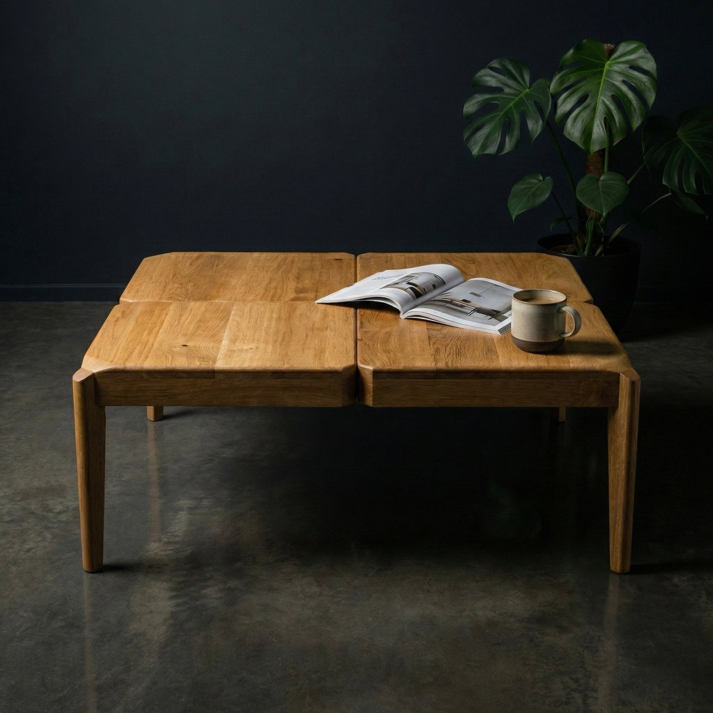 Wooden coffee table with a magazine and cup on a dark floor and wall background