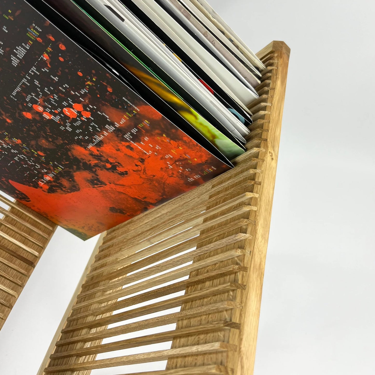 wooden vinyl stand with records on a white background