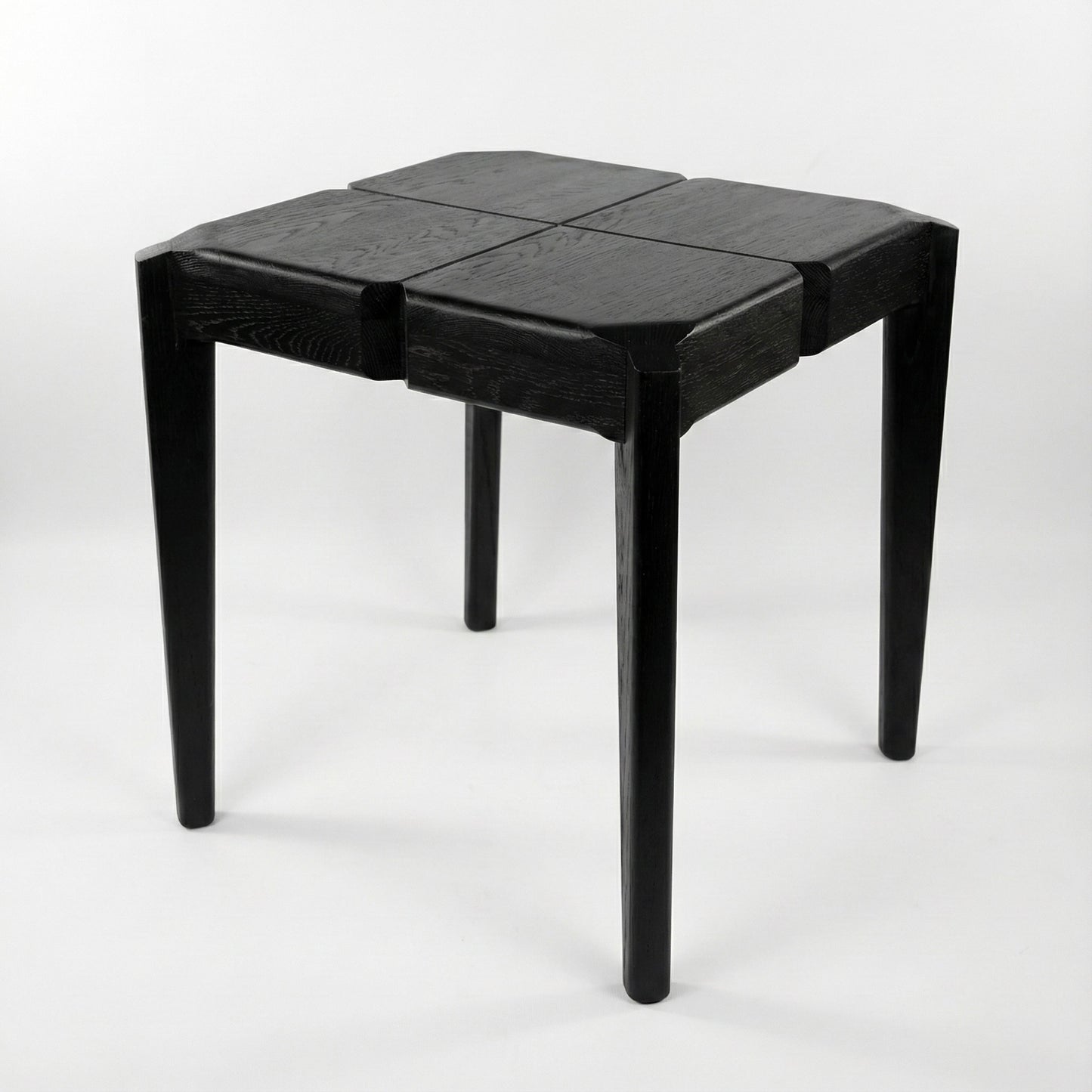 Black geometric stool or a side table on a white background